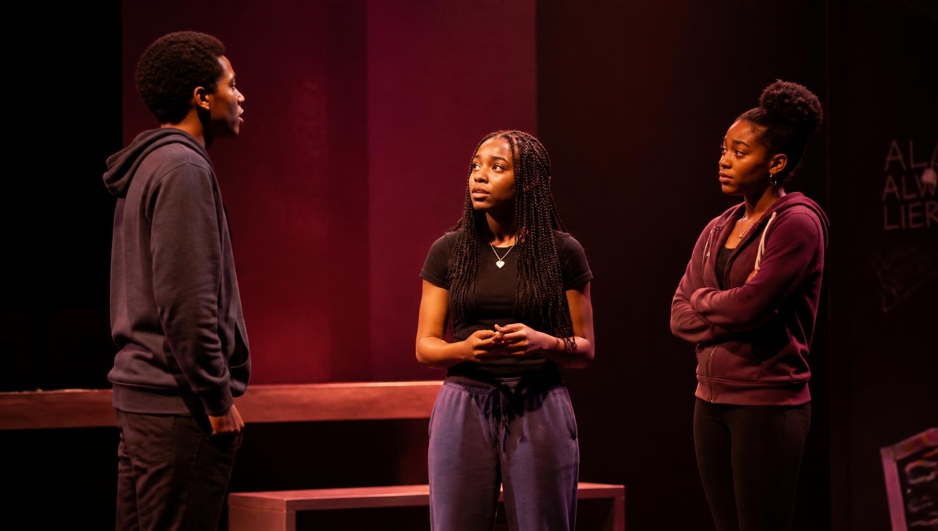 Student actors performing on a lit stage